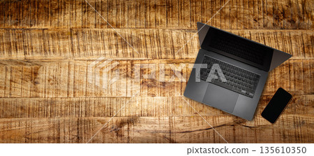 Modern blank dark grey laptop on vintage wooden table Modern blank dark grey laptop on vintage wooden table 135610350