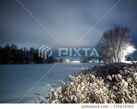 A frozen snow-covered river on a winter night 135610565