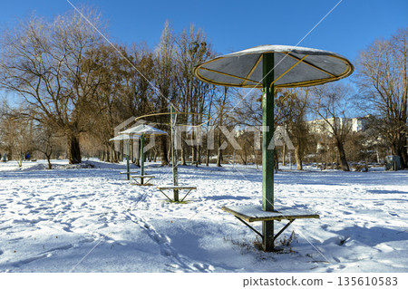 Umbrella-shaped canopies on a snowy winter beach on a clear day Umbrella-shaped canopies on a snowy winter beach on a clear day 135610583