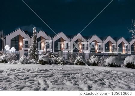 Townhouses covered in snow on a winter night Townhouses covered in snow on a winter night 135610603