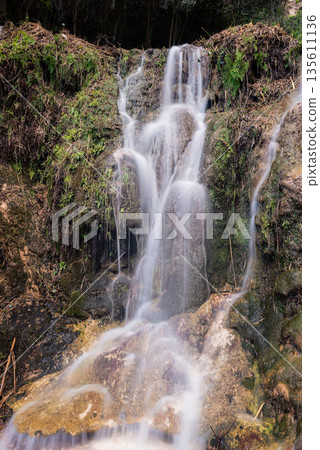 Blurred Water Cascading Over Green Mossy Rocks Blurred Water Cascading Over Green Mossy Rocks 135611136