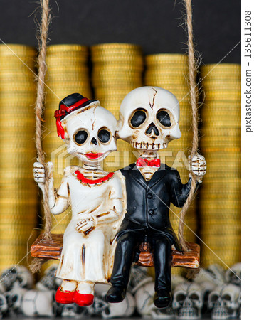 Skeleton bride and groom on swing before gold coin stacks and skulls 135611308