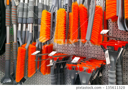Snow and ice removal brushes and tools displayed on store pegboard wall Snow and ice removal brushes and tools displayed on store pegboard wall 135611320