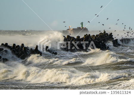 Powerful storm waves crash against breakwater near Liepaja harbor gate on the Baltic Sea coast Powerful storm waves crash against breakwater near Liepaja harbor gate on the Baltic Sea coast 135611324
