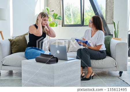 Sad stressed young woman patient in therapy session in psychologist office 135611495