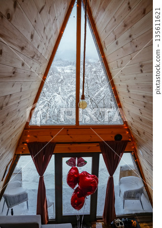 Cozy A-Frame Wooden Cabin Interior with Large Panoramic Window Cozy A-Frame Wooden Cabin Interior with Large Panoramic Window 135611621