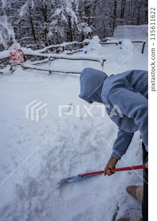 Woman Removing Snow with Mop, Face Not Visible Woman Removing Snow with Mop, Face Not Visible 135611622