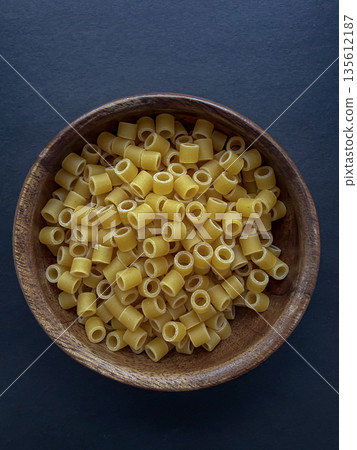 Dry Ditalini Pasta in Wooden Bowl on Dark Background Dry Ditalini Pasta in Wooden Bowl on Dark Background 135612187