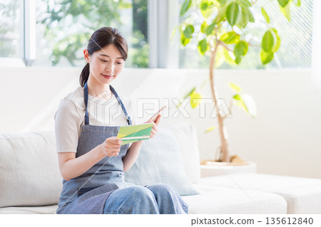 一位年輕的家庭主婦正在查看她的銀行存摺。 135612840