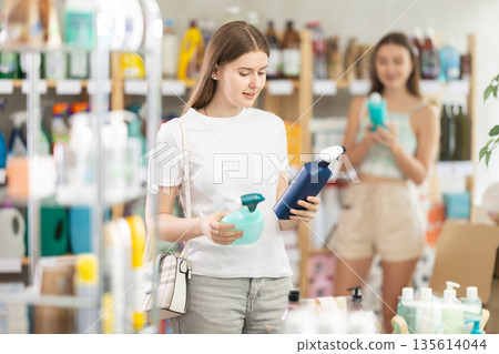 Young woman chooses cleaning spray in store 135614044
