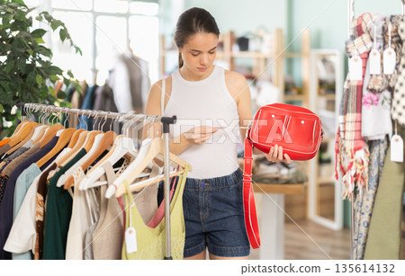 Young women choosing handbag in store Young women choosing handbag in store 135614132