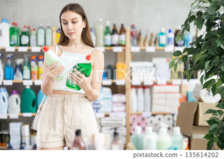Woman view trademark sign on label, chooses eco friendly dishwashing detergent 135614202