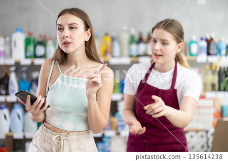 saleswoman shows a woman the range of products in a household store saleswoman shows a woman the range of products in a household store 135614238