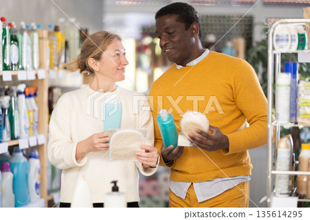 Couple man and woman choosing shampoo or shower gel and washcloth Couple man and woman choosing shampoo or shower gel and washcloth 135614295