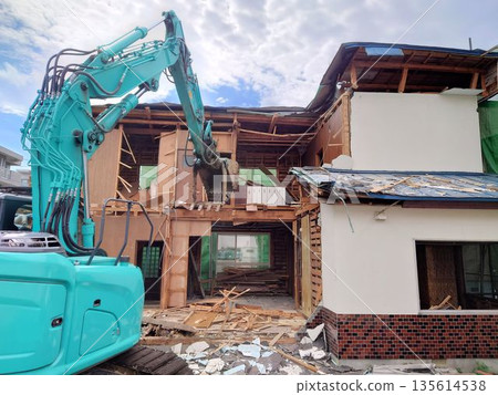 A residential demolition site and heavy machinery (backhoe) in operation A residential demolition site and heavy machinery (backhoe) in operation 135614538