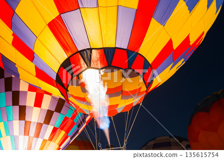 colorful hot air balloons glowing against dark night sky 135615754