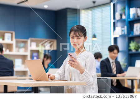 在辦公室工作的年輕女商人 在辦公室工作的年輕女商人 135615867