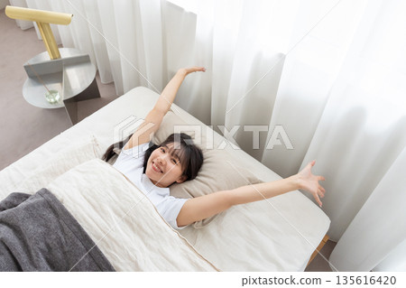 一個女人在床上伸展 135616420