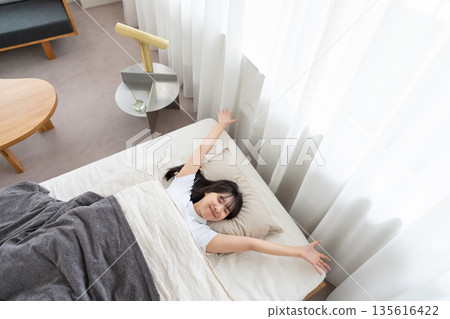 一個女人在床上伸展 一個女人在床上伸展 135616422