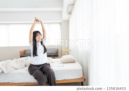 A woman who wakes up in the morning and stretches 135616433