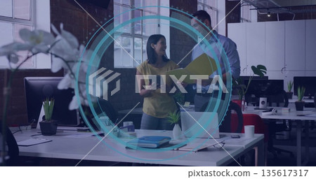 Collaborating colleagues wearing shirt and blouse holding tablet and folder in open-plan office Collaborating colleagues wearing shirt and blouse holding tablet and folder in open-plan office 135617317