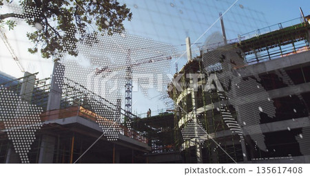 Standing worker wearing hard hat and hi-vis vest inspecting columns at building site with crane Standing worker wearing hard hat and hi-vis vest inspecting columns at building site with crane 135617408