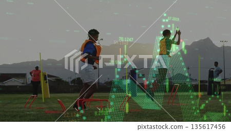 Jumping girl wearing yellow training bib navigating red hurdles on local field, with green overlay Jumping girl wearing yellow training bib navigating red hurdles on local field, with green overlay 135617456