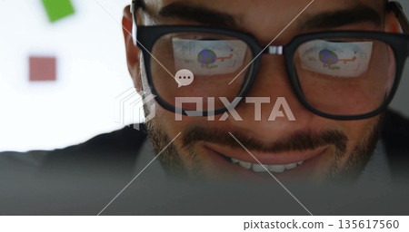 Leaning man wearing black glasses reflecting charts on laptop screen in office with red green notes Leaning man wearing black glasses reflecting charts on laptop screen in office with red green notes 135617560