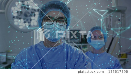 Performing surgery Chinese male surgeon operating in OR, with lights, monitors, holographic display 135617596