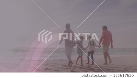 Walking four barefoot family members holding hands on sandy beach, with ocean waves and horizon 135617630