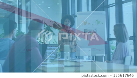 Presenting businesswoman wearing mustard blouse, pants in meeting room with flipchart and laptops Presenting businesswoman wearing mustard blouse, pants in meeting room with flipchart and laptops 135617646