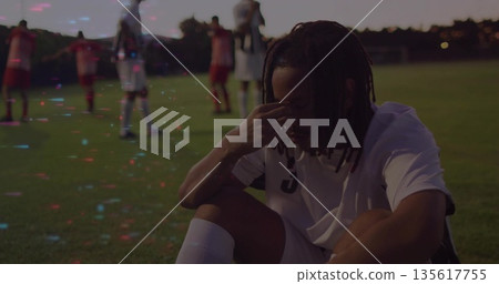 Crouching soccer player pressing forehead on grass field, showing white jersey number 3, copy space Crouching soccer player pressing forehead on grass field, showing white jersey number 3, copy space 135617755
