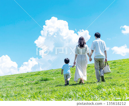 Back view of a Japanese family walking under the blue sky | A happy holiday scene with parents and children holding hands 135618212