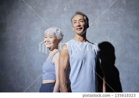Portrait of senior man and woman exercising on black background 135618323