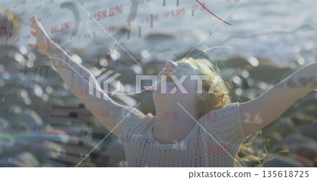 Basking adult woman wearing sweater stretching arms on rocky shoreline by water, with data overlays Basking adult woman wearing sweater stretching arms on rocky shoreline by water, with data overlays 135618725