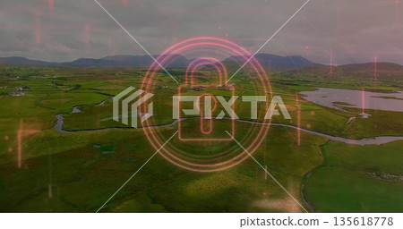 Hovering neon pink digital padlock icon showing security interface over rural fields with waterways 135618778