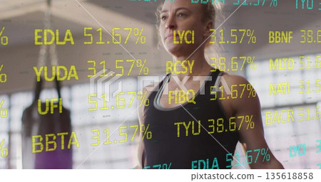 Standing athletic woman tracking digital overlay metrics in studio, with punching bag, copy space 135618858