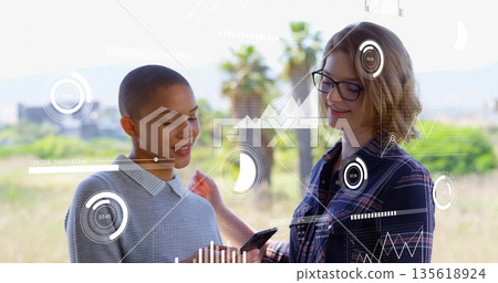 Reviewing two colleagues tapping smartphone and analyzing data overlays in grassy field Reviewing two colleagues tapping smartphone and analyzing data overlays in grassy field 135618924