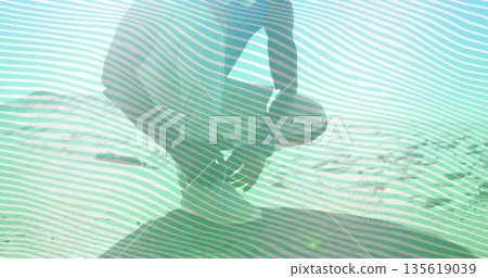 Kneeling shirtless man in shorts gazing across rippled sand dune under bright sun, with lens flare Kneeling shirtless man in shorts gazing across rippled sand dune under bright sun, with lens flare 135619039