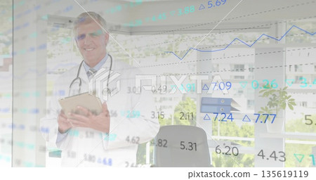 Reviewing senior doctor with stethoscope checking tablet in medical office, showing graph overlays Reviewing senior doctor with stethoscope checking tablet in medical office, showing graph overlays 135619119