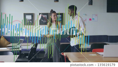 Coworkers wearing casual attire discussing business data overlays in coworking office, with laptops Coworkers wearing casual attire discussing business data overlays in coworking office, with laptops 135619179