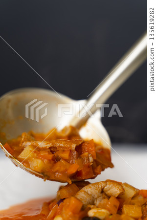 Ladle the white offal stew into a plate. Ladle the white offal stew into a plate. 135619282
