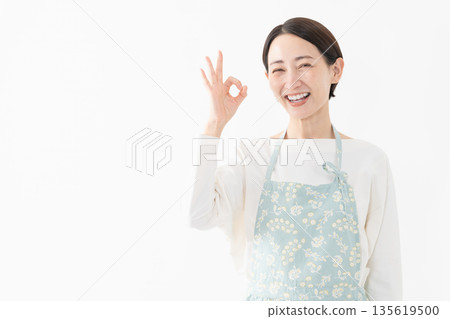 Woman wearing an apron Lifestyle image Woman wearing an apron Lifestyle image 135619500