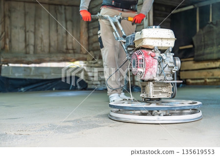 Concrete Finishing Worker Smoothing Surface with Power Trowel, Construction and Renovation 135619553