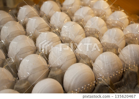 A carton of eggs with a plastic lid 135620467