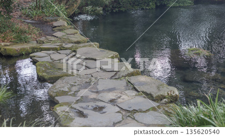 Stone bridge at Myojinike Meisui Park in winter 135620540