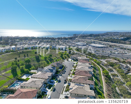Aerial view over San Juan Capistrano, California, featuring the historic mission, library, sports courts, and an Amtrak train pulling into the downtown station. 135620719