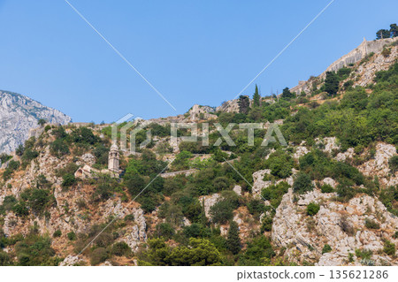 A rugged hillside scene featuring ancient stone chapel and Kotor fortress A rugged hillside scene featuring ancient stone chapel and Kotor fortress 135621286