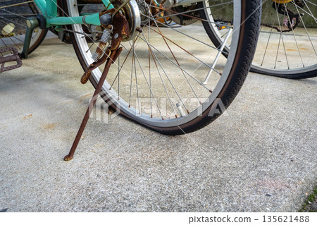 An old, rusty bicycle with a flat tire 135621488