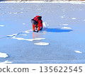 A climber bends down to photograph something on the ice (afr20260110093552) 135622545